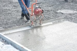robotnik budowlany dodający domieszki do mieszanki betonowej na placu budowy