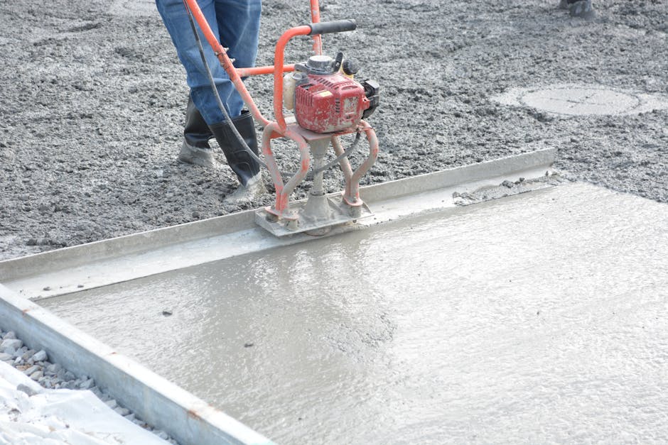 robotnik budowlany dodający domieszki do mieszanki betonowej na placu budowy