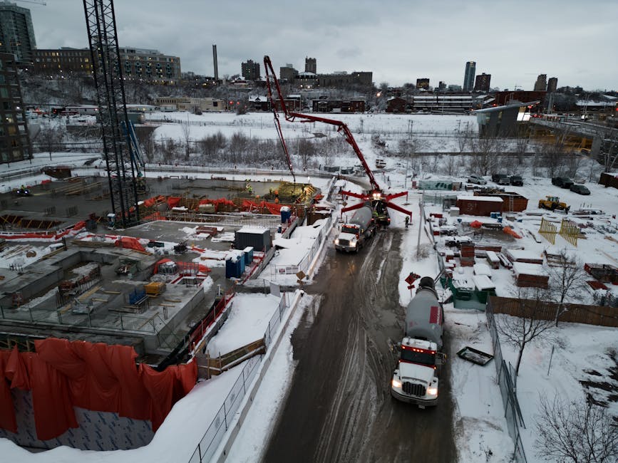 plac budowy zimą z betonomieszarką w trakcie wylewania betonu