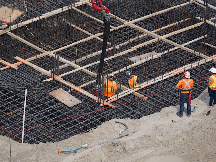 pracownik budowlany układający zbrojenie pod beton na placu budowy