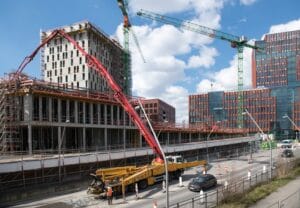 Profesjonalna pompa do betonu pracująca na placu budowy przy wylewaniu fundamentów domu jednorodzinnego